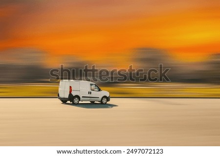 White cargo van. Small light truck is driving on an asphalt street with a speed blur background. Cargo, goods delivery, courier services concept.