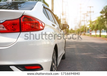 White cars parked on the roadside, with natural backgrounds and with bright sunlight.