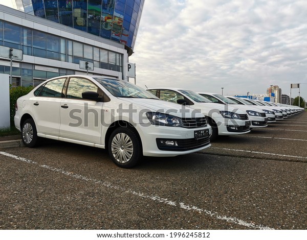 White cars are standing in a
row. There are new cars for sale. Sale of new cars in car
dealerships.