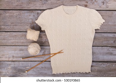 White Cashmere Blouse With Yarn And Wooden Knitting Needles. Warm Sweater With Short Sleeves.