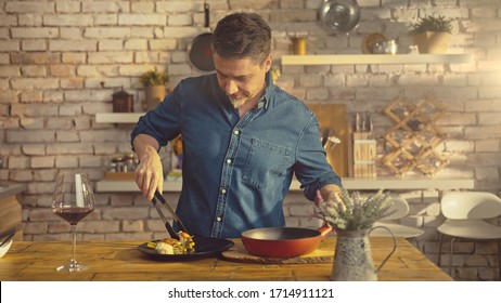 White Casual Man Cooking In Kitchen At Home Serving Food To Plate On Dinner Table