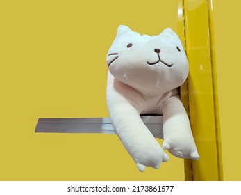 White Cat, Cute Toy On Sale Shelf With Yellow Background Isolated. Cat Plush Pillow