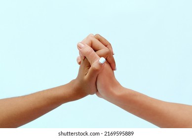 White Caucasian Female Hands And Black African American Hands Hold Fingers Together In World Unity And Racial Love And Understanding In Tolerance And Racial Diversity Cooperation Concept On Blue