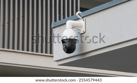 White cctv dome camera providing surveillance at building entrance, enhancing security and safety