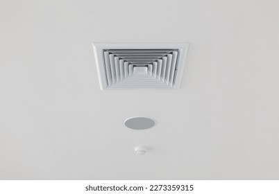 White ceiling ventilation grille with rectangular diffuser and smoke catch. close up photo