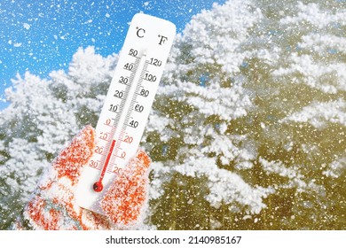 White celsius and fahrenheit scale thermometer in hand. Ambient temperature minus 8 degrees celsius