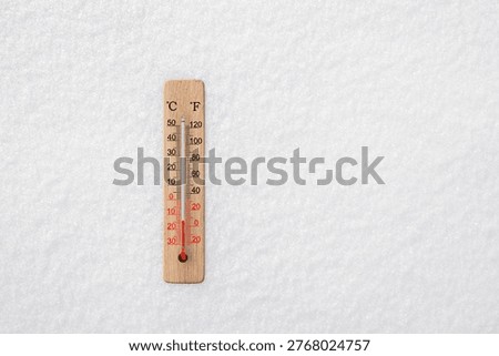White celsius and fahrenheit scale thermometer in snow. Ambient temperature minus 14 degrees celsius