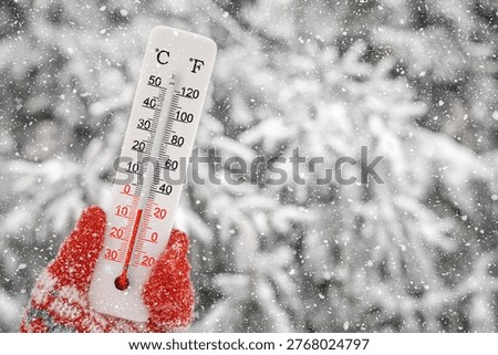 White celsius and fahrenheit scale thermometer in hand. Ambient temperature minus 5 degrees celsius