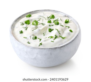 White ceramic bowl of fresh sour cream dip sauce with herbs isolated on white background