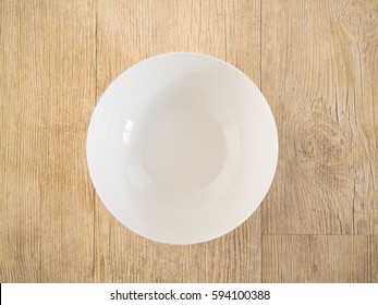 White ceramic bowl or plate on a wood deck.