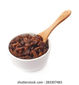 White ceramic cup filled with multiple raisins and the wooden spoon inside, composition isolated over the white background