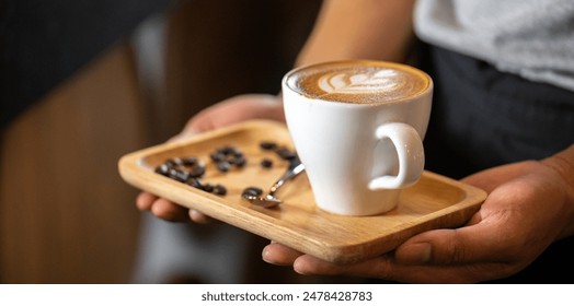 White ceramic cups of cappuccino with latte art Barista make coffee by pouring spills hot milk cream on black coffee. Barista serve holding cup of hot latte and coffee beans on wooden table cafe shop - Powered by Shutterstock