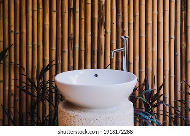 White ceramic hand and wash basin with the bamboo wall background and the tree at outdoor