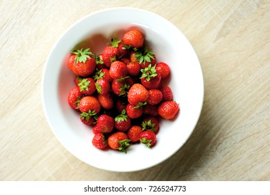 White Ceramic Kitchen Bowl Full Of Red Strawberries Taken From An Aerial Overhead Position With Domestic Counter Background.