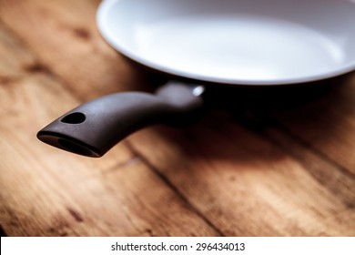 White Ceramic Pan With A Black Pen On The Old Wooden Table.