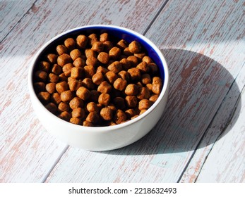 White Ceramic Pet Bowl With Dry Dog Food Or Cat Feed On A Light Background.