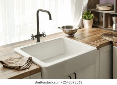 White ceramic sink on wooden counter near window in comfortable kitchen