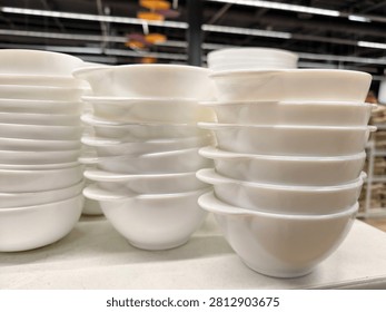 White ceramic tableware including handled bowls arranged on supermarket shelving