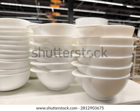 White ceramic tableware including handled bowls arranged on supermarket shelving