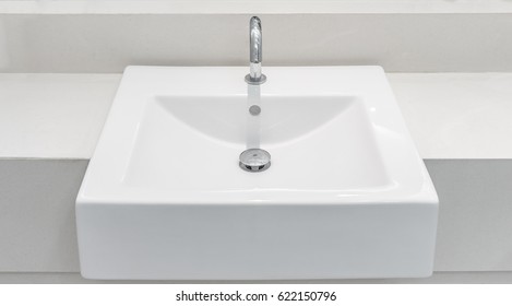 White Ceramic Wash Basin With A Automatic Tap And Drain. It Is Also Known As Sink, Sinker, Washbowl And Hand Basin.