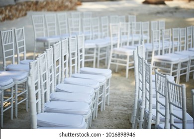 white chairs set up on the beach for wedding 