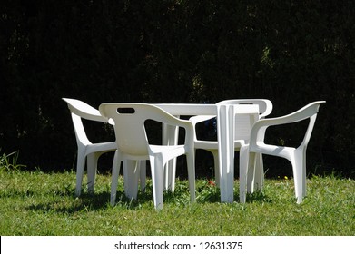White chairs and table in lawn of garden