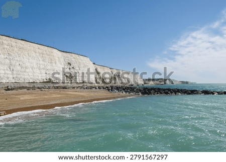 White chalk cliffs and shingle beach with breakwater by Brighton Marina in East Sussex, England.