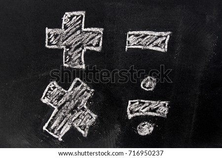 White chalk drawing in basic mathematics symbol (plus minus multiply divide) on black board background