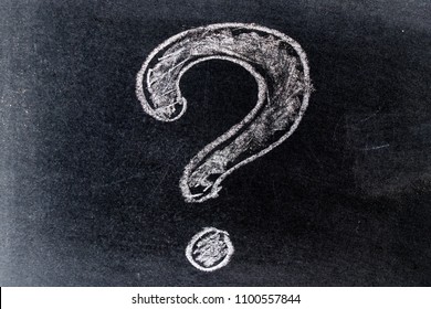 White chalk drawing in questionmark shape on black board background