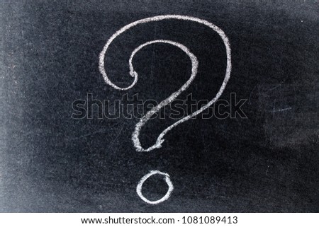 White chalk drawing in questionmark shape on black board background