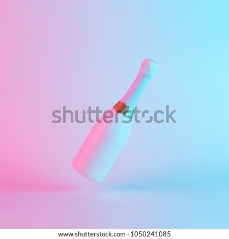 White champagne bottle with colorful ultraviolet holographic neon lights. Creative concept.