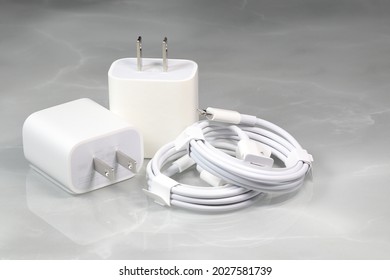White charger adapters and white USB cables on a white background, New Chargers and cable connectors for gadgets isolated on a white background. The concept of charging technology to mobile phones. 