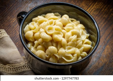 White Cheddar Shell Macaroni And Cheese On Rustic Wooden Table With Dark Moody Lighting