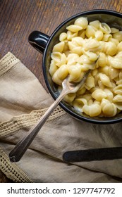 White Cheddar Shell Macaroni And Cheese On Rustic Wooden Table With Dark Moody Lighting