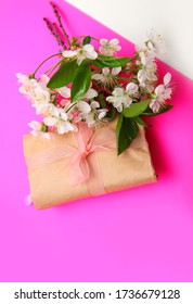 White cherry blossoms with a paper gift on fuchsia background. Three flowering branches, detail