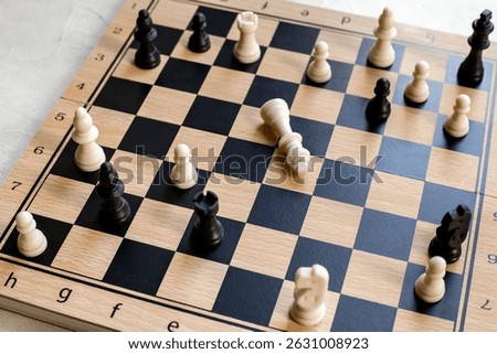 White chess king laying down on chessboard after checkmate.