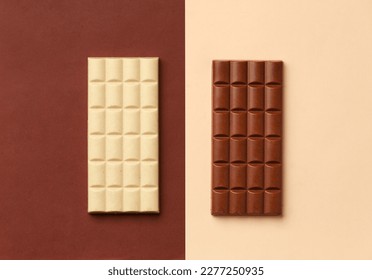 White chocolate bar on a brown background, milk chocolate bar on a beige background top view, chocolate on contrasting backgrounds. - Shutterstock ID 2277250935