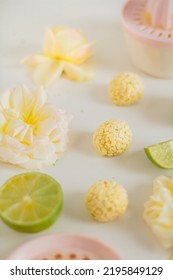 White Chocolate Candies And Lemon Slices On White Background. Food Styling. Spring And Summer Comfort Food.