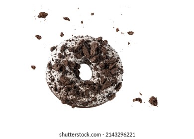 White chocolate glazed donut with dark cookies crumbs and creme filled closeup flying. Sweet doughnut falling isolated on white background