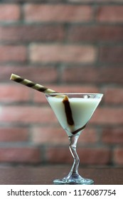 White Chocolate Martini Garnish With A Stick On The Desk With Bricks Wall Close Up