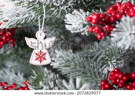 white Christmas angel on a tree. Wooden angel on the Christmas tree. festive background with christmas toy