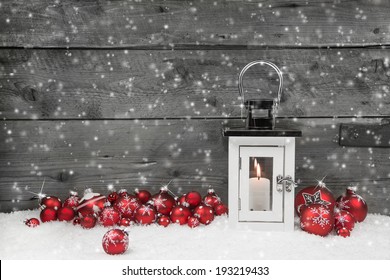 White christmas candle in a lantern and red balls on a grey shabby wooden background. - Powered by Shutterstock