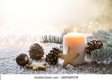 White Christmas candle on rustic wooden boards - Decoration with natural elements, twigs, pine cones and cookies.