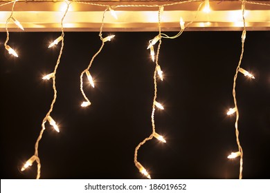 White Christmas Lights On Roof Against Dark Background