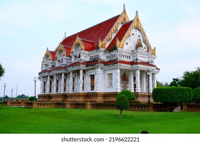 White Church Building With Brown Base Surrounded By Green Grass And Trees