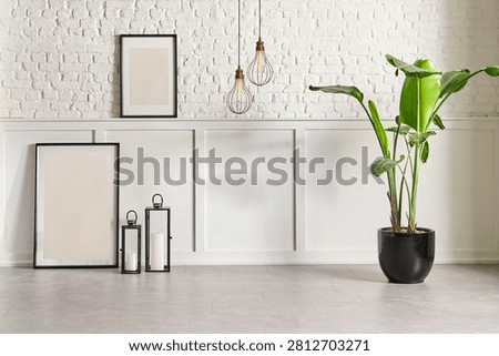 White classic and brick wall background concept, interior room, vase of green plant, black chair, frame, house appliance, marble floor.