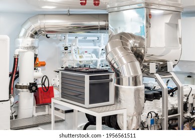 White and clean Engine Room of a modern superyacht with tool box, engine and different pumps