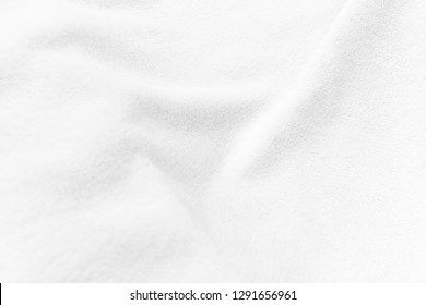 White Clean Soft Smooth Fleece Fabric Blanket Texture With Curves, Creases And Folds. For Background And Wallpaper With Room For Text And Copy Space.