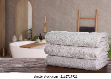 Toallas limpias blancas sobre una mesa de madera en el cuarto de baño. Espacio para texto