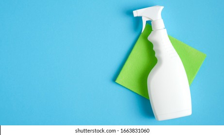 White cleaner spray bottle and green rag on blue background. Flat lay, top view. House cleaning service and housekeeping concept - Powered by Shutterstock